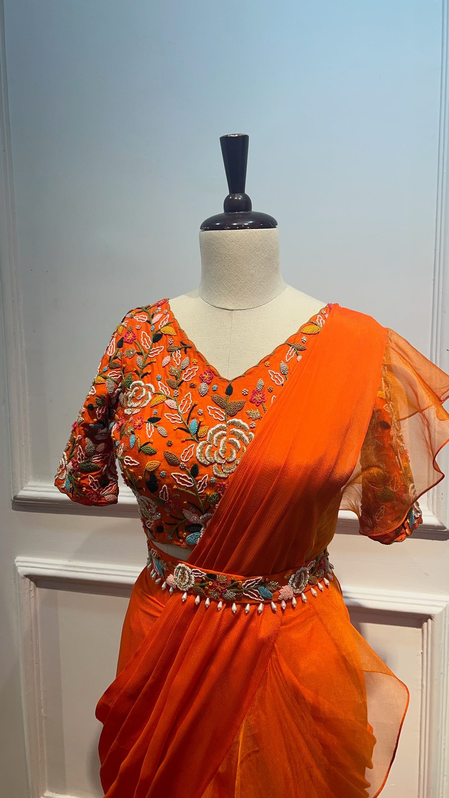 Orange Pre Draped Ruffle Saree paired with raw silk thread and knot work blouse