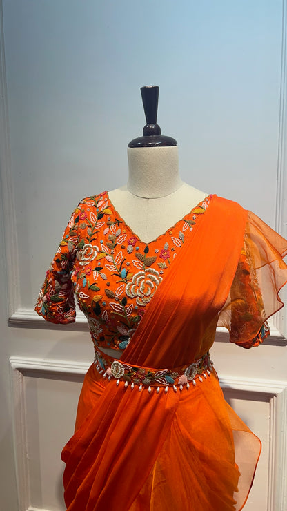 Orange Pre Draped Ruffle Saree paired with raw silk thread and knot work blouse