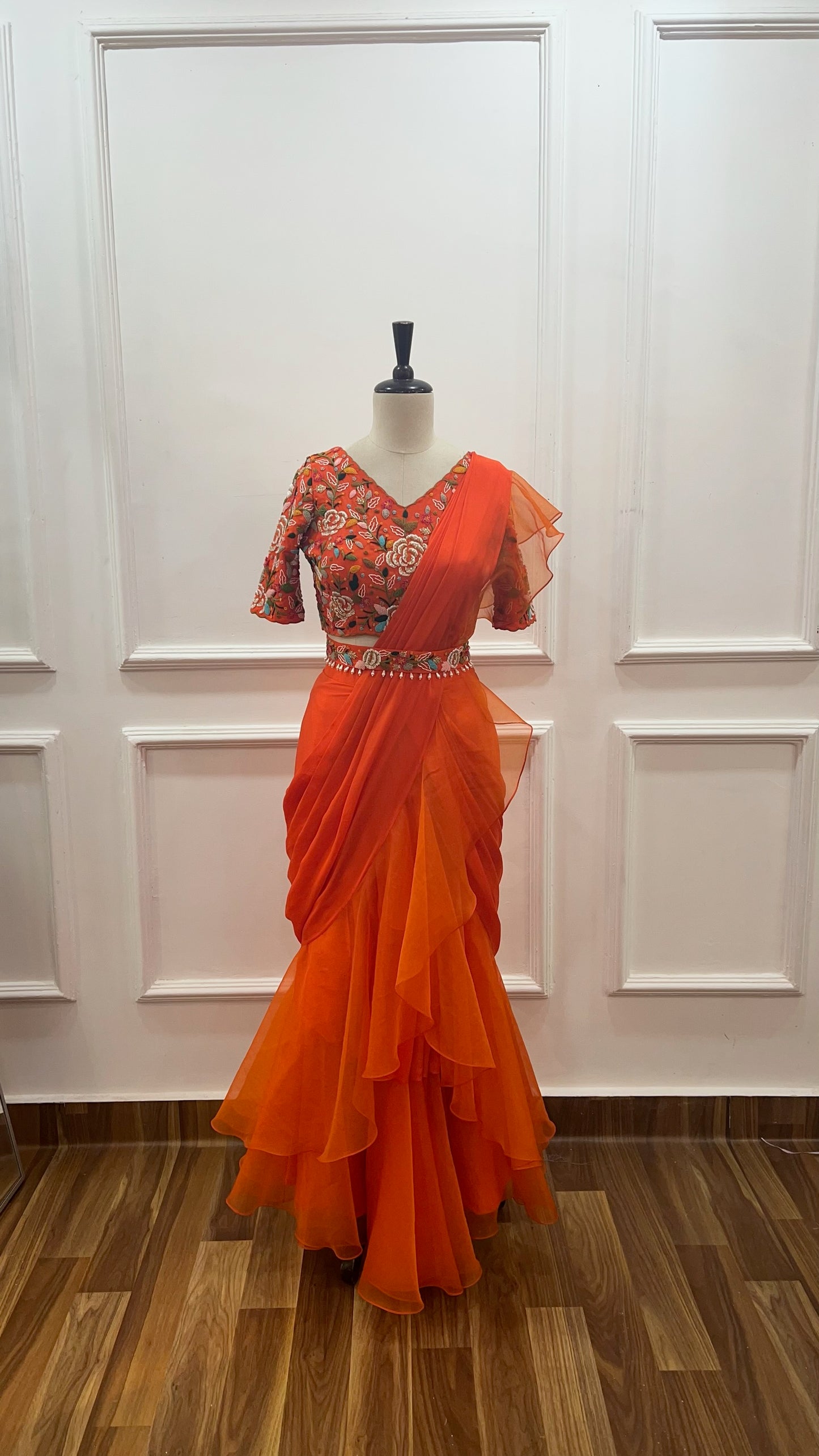 Orange Pre Draped Ruffle Saree paired with raw silk thread and knot work blouse