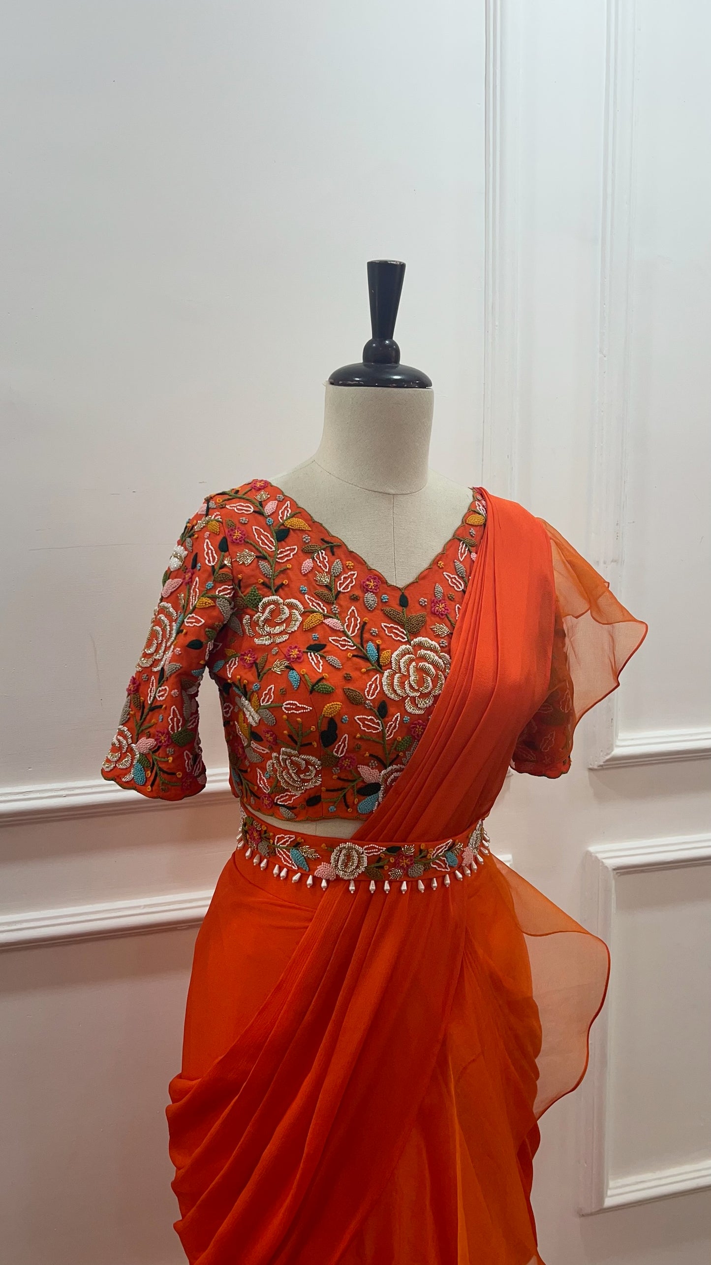 Orange Pre Draped Ruffle Saree paired with raw silk thread and knot work blouse